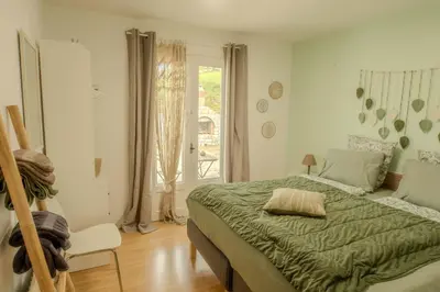a bedroom with a green bed and a window at La Bastide in Puycalvel Lautrec