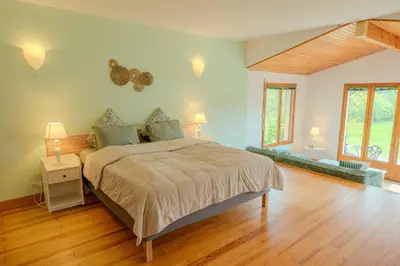 a bedroom with a large bed and a wooden floor at La Bastide in Puycalvel Lautrec