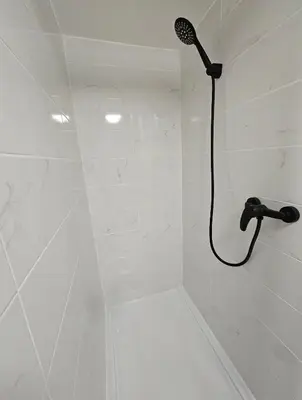 a shower with a black shower head in a bathroom at Tout confort ! Ville, Calme, Cinéma privé, Climatisation, Parking, WiFi in Carcassonne