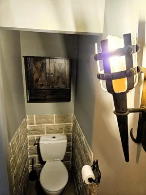 a bathroom with a toilet and a statue of a gun at Tout confort ! Ville, Calme, Cinéma privé, Climatisation, Parking, WiFi in Carcassonne
