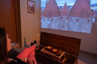 a woman sitting in front of a screen with two donuts at Tout confort ! Ville, Calme, Cinéma privé, Climatisation, Parking, WiFi in Carcassonne