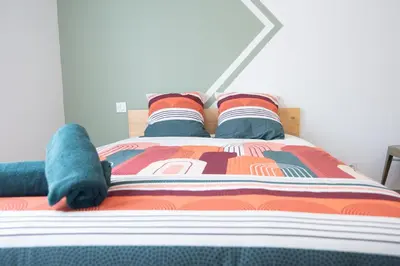 a bed with a stuffed animal on top of it at Tout confort ! Ville, Climatisation, Parking, Wifi, Calme, TV in Carcassonne