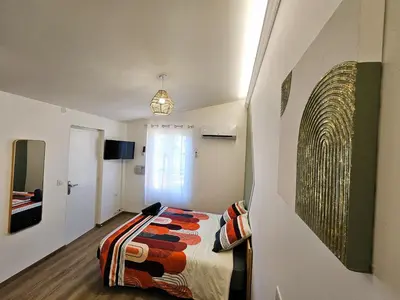 a bedroom with a bed and a painting on the wall at Tout confort ! Ville, Climatisation, Parking, Wifi, Calme, TV in Carcassonne