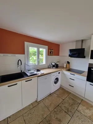 a kitchen with white cabinets and a sink and a dishwasher at Cyprès de vos rêves in Ornaisons