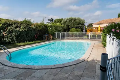 a swimming pool with blue water in a yard at Cyprès de vos rêves in Ornaisons