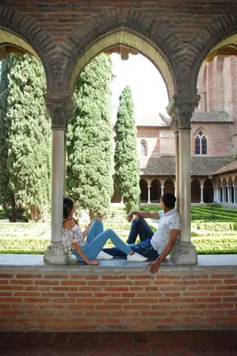two people sitting on a bench in a building at Le Cavalier in Caraman