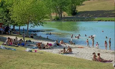 a group of people on a beach near a body of water at Le Cavalier in Caraman