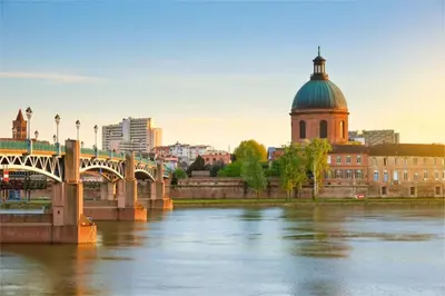 a bridge over a river in front of a city at Le Cavalier in Caraman