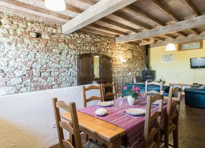 a dining room with a wooden table and chairs at Le Cavalier in Caraman