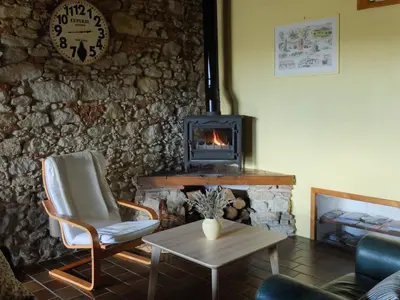a living room with a stone wall with a fireplace at Le Cavalier in Caraman
