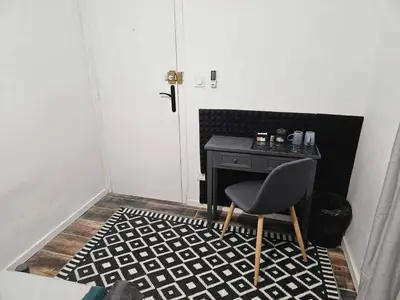 a room with a chair and a table and a door at AV de Bordeaux in Narbonne