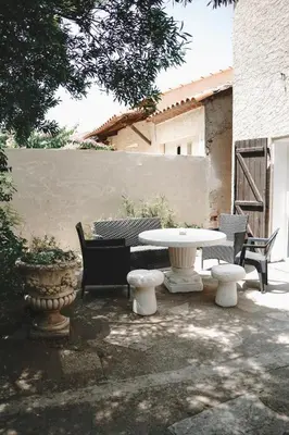 a patio with a white table and chairs at AV de Bordeaux in Narbonne