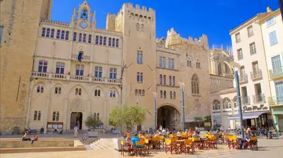 a group of people sitting at tables in front of a building at AV de Bordeaux in Narbonne
