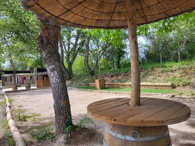 an umbrella sitting on top of a wooden table at Camping Le Val de Cesse in Mirepeisset