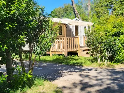 a wooden cabin with a porch and a deck at Camping Le Val de Cesse in Mirepeisset