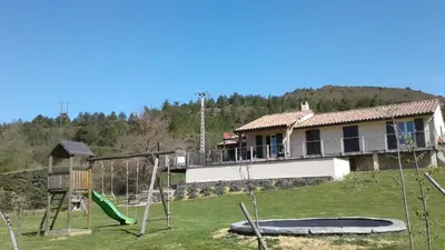 a house with a playground in front of it at Maison Des Levriers met zwemvijver en airco in Katharenland in Luc-sur-Aude