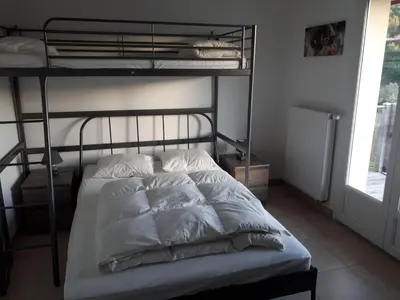 a bedroom with a bunk bed with white sheets and pillows at Maison Des Levriers met zwemvijver en airco in Katharenland in Luc-sur-Aude