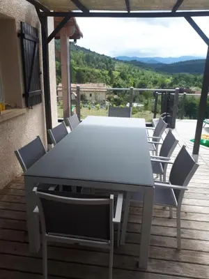 a white table and chairs on a deck with a view at Maison Des Levriers met zwemvijver en airco in Katharenland in Luc-sur-Aude