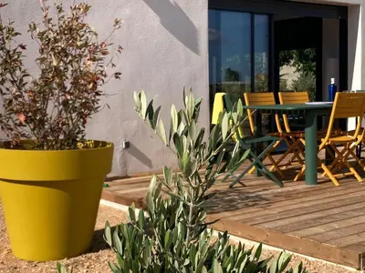 a patio with a table and chairs on a deck at Stylish Villa in Sainte-Valière in Sainte-Vallière