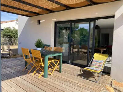 a patio with a table and chairs on a deck at Stylish Villa in Sainte-Valière in Sainte-Vallière