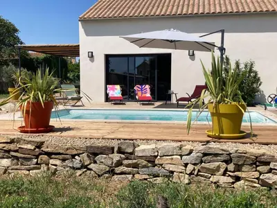 a house with a swimming pool and an umbrella at Stylish Villa in Sainte-Valière in Sainte-Vallière