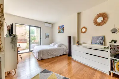 a bedroom with a bed and a dresser at Le Couvent des Ursulines - Penthouse climatisé piscine in Narbonne