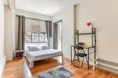 a bedroom with a bed and a window at Le Couvent des Ursulines - Penthouse climatisé piscine in Narbonne