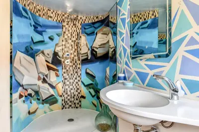 a bathroom with a sink and a colorful wall at Le Couvent des Ursulines - Penthouse climatisé piscine in Narbonne