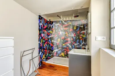a room with a wall covered in colorful art at Le Couvent des Ursulines - Penthouse climatisé piscine in Narbonne