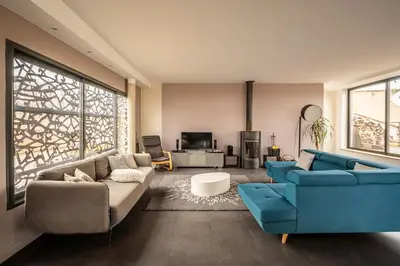 a living room with two blue couches and a tv at Le Couvent des Ursulines - Penthouse climatisé piscine in Narbonne