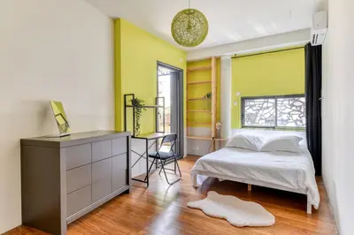 a bedroom with a bed and a desk and a window at Le Couvent des Ursulines - Penthouse climatisé piscine in Narbonne