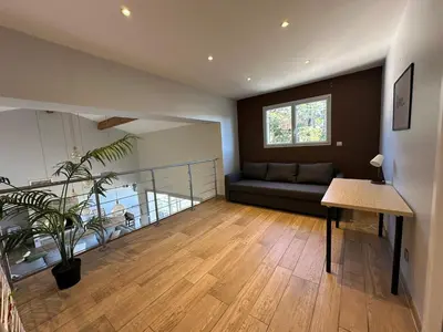 a living room with a couch and a table at Maison paisible toute équipée, piscine chauffée in Sallèles-dʼAude