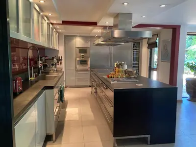 a large kitchen with stainless steel appliances and counters at Maison exceptionnelle piscine in Aussillon