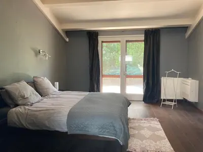 a bedroom with a bed and a large window at Maison exceptionnelle piscine in Aussillon