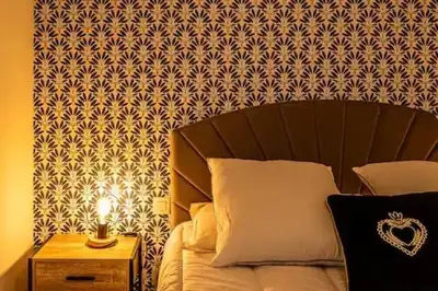 a bedroom with a bed and a night stand with a lamp at Le clos des jacobins in Narbonne