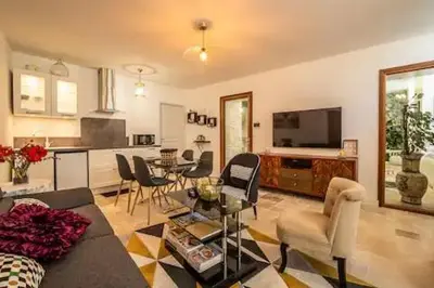 a living room with a table and chairs and a kitchen at Le clos des jacobins in Narbonne