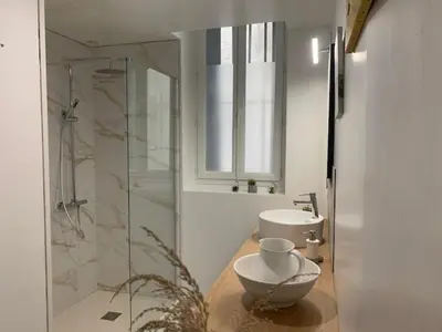 a bathroom with a glass shower and a sink at Le clos des jacobins in Narbonne