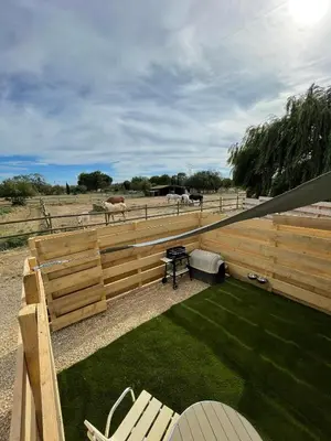a wooden fence with a picnic table and a horse in a field at Studio à l'Ecurie in Narbonne