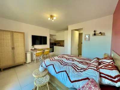 a bedroom with a large bed and a kitchen at Studio à l'Ecurie in Narbonne