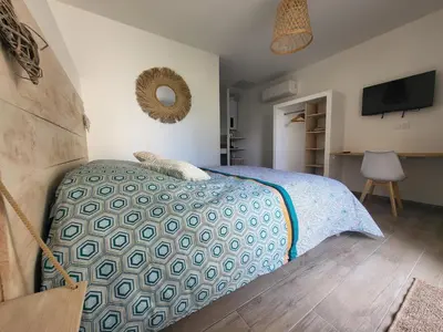 a bedroom with a bed with a blue comforter at Chambre Le Ka-Marrant in Les Pujols