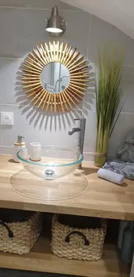 a bathroom sink with a large mirror above it at Le Cosy in Caraman