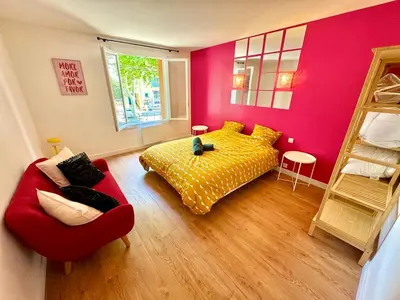 a bedroom with a yellow bed and a red couch at Evasion dépaysante Canal du Midi La vie en couleur in Castelnaudary