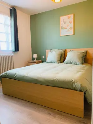 a bedroom with a large bed with a wooden frame at Maison proche de la Cité avec jardin in Carcassonne