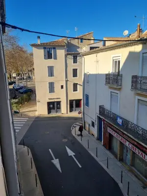 a person walking down a street next to a building at Cosy Hypercentre Netflix in Narbonne