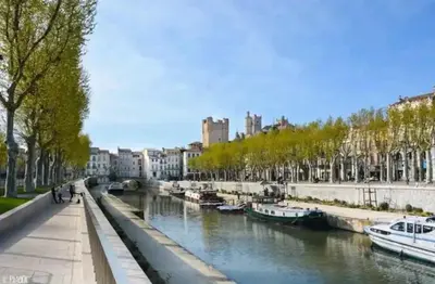 a river in a city with boats in it at Cosy Hypercentre Netflix in Narbonne