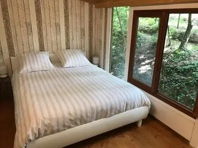 a bed in a room with a window at Bus atypique au bord du canal du midi et au cœur d'une forêt 2 chambres in Villepinte