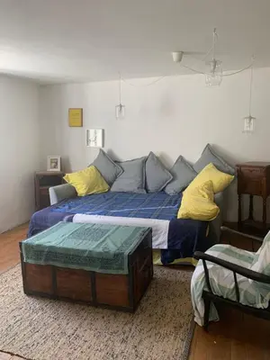 a bedroom with a bed with blue sheets and yellow pillows at Havre de paix in Mas-Cabardès