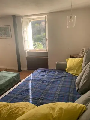 a bedroom with a large bed and a window at Havre de paix in Mas-Cabardès
