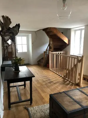 a living room with stairs and a table in a room at Havre de paix in Mas-Cabardès