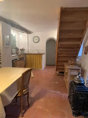 a kitchen and dining room with a table and a staircase at Havre de paix in Mas-Cabardès
